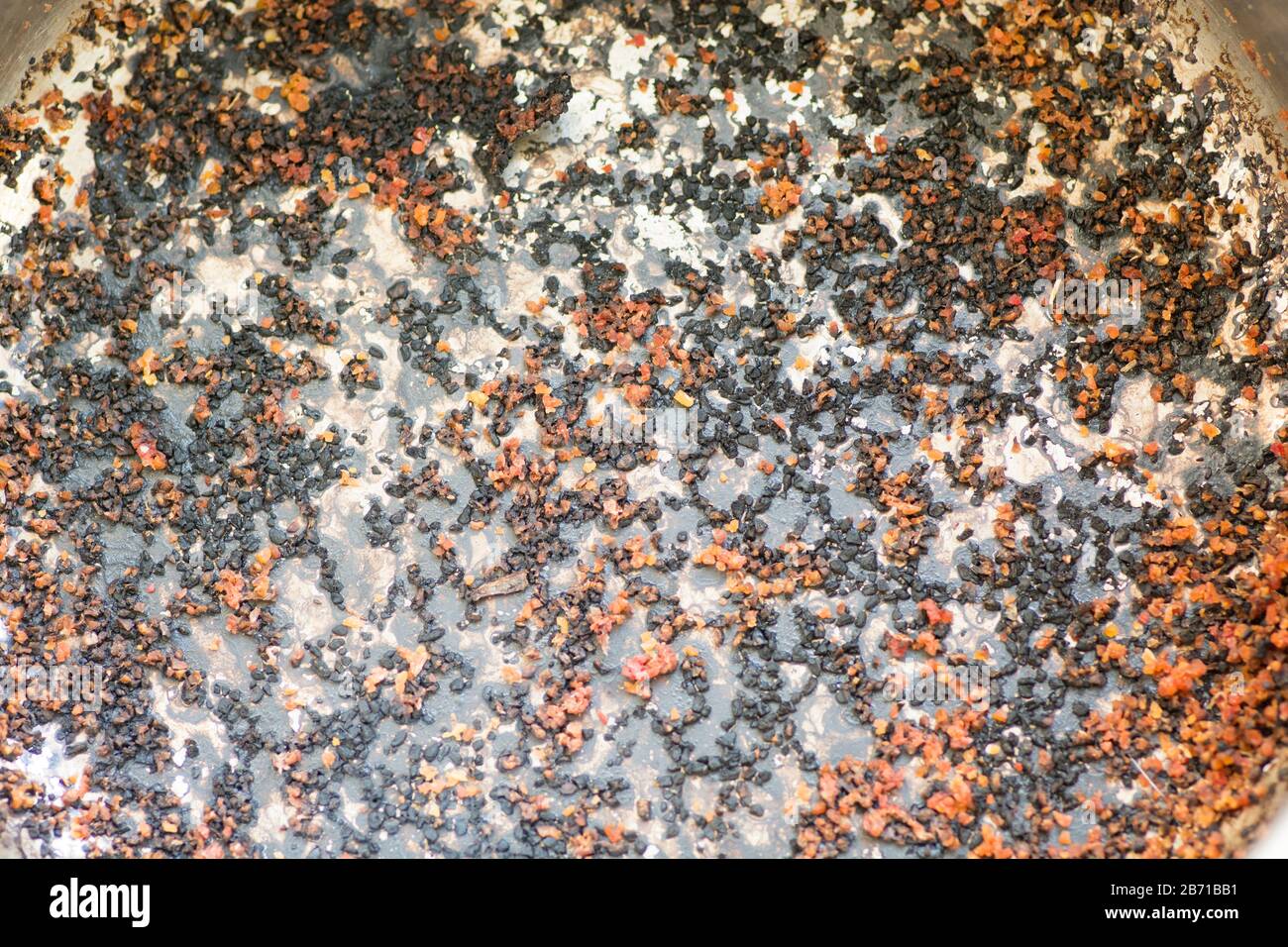 Texture d'un fond de pot brûlé, avec des couleurs de rouge et de noir Banque D'Images