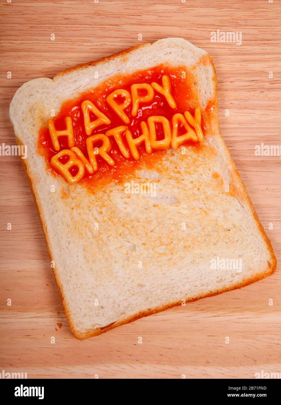 Les mots Happy Birthday sont énoncés sur une tranche de pain grillé avec des spaghetti de l'alphabet Banque D'Images