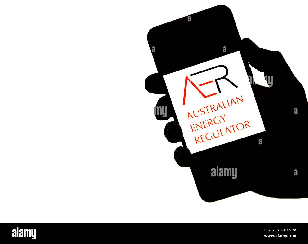 Stone / Royaume-Uni - 11 mars 2020: AER Australian Energy Regulator logo sur la silhouette du téléphone portable tenir dans la main. L'écran blanc brillant est allumé Banque D'Images
