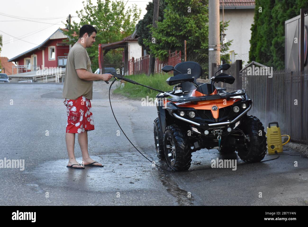 Laver un quad avec un fusil de lavage de voiture Banque D'Images Laver un quad avec un fusil de lavage de voiture Banque D'Images