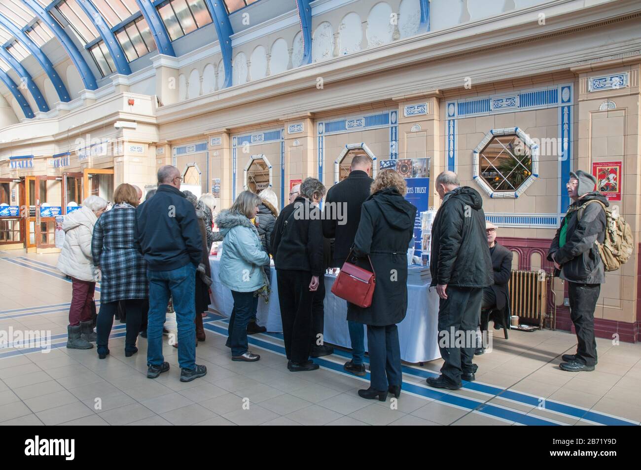 Groupe de personnes hommes et femmes à la table d'information pendant la journée publique ouverte aux Jardins d'hiver Blackpool Lancashire Angleterre Royaume-Uni. Banque D'Images