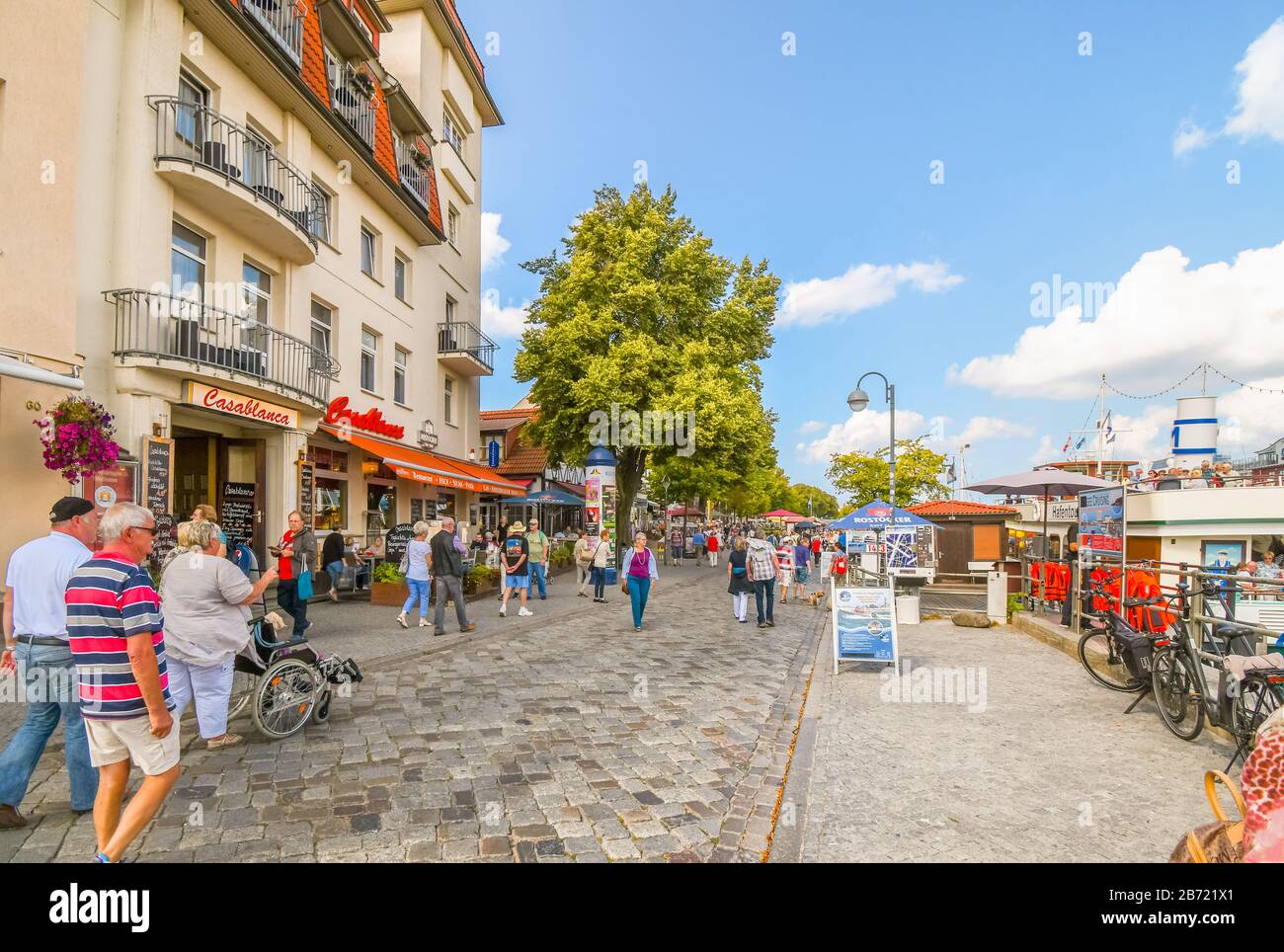 Les touristes peuvent profiter d'une journée d'été ensoleillée sur la promenade de la promenade le long du canal Alter Strom à Warnemunde Rostock, en Allemagne. Banque D'Images Les touristes peuvent profiter d'une journée d'été ensoleillée sur la promenade de la promenade le long du canal Alter Strom à Warnemunde Rostock, en Allemagne. Banque D'Images