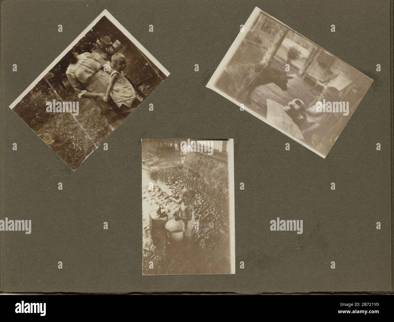 Leprozenkolanie Danaradja klein genre Album feuille avec trois photos du même enfant: En haut à gauche avec une femme, à droite avec un chien, y compris jouer avec l'eau. C'est peut-être là un enfant du Dr C. Grams Berg et de son épouse H. Gram-Berg Goossen, tous deux travaillant dans la colonie de léper Dana Raja. Partie de la colonie de léper de photo Album Dana Rajah et familliéopnoms. Fabricant : Photographe: Fabrication de localisation anonyme: Kelet Dating: 1922 Caractéristiques physiques: Papier lumière du jour matériel d'impression: Papier carton technique: Papier jour dimensions: Feuille d'album: H 190 mm × W 260 mm Sujet: Leprosydogchild Banque D'Images