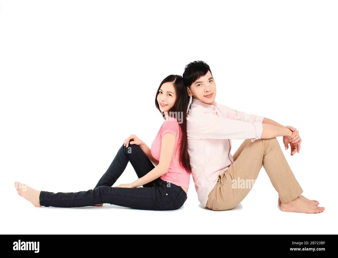 jeune couple asiatique assis sur le sol isolé sur fond blanc Banque D'Images