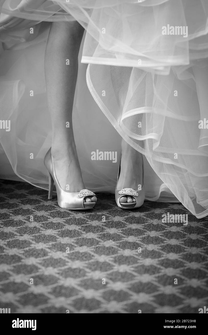 Jambes noires et blanches de la mariée en soie haute pompes guéries et robe de tulipe Banque D'Images