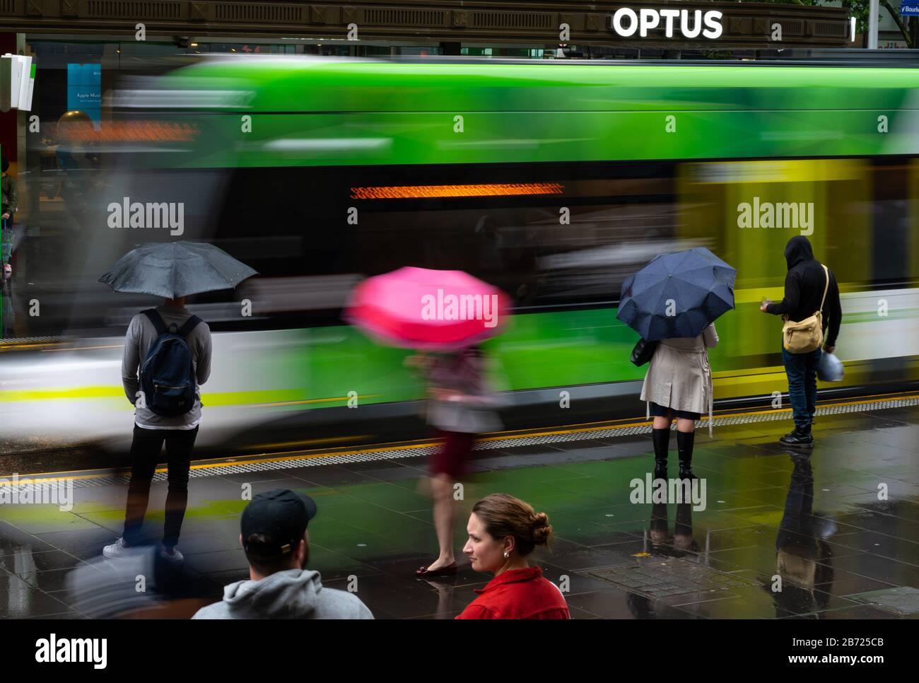 Les navetteurs attendent un tramway dans la rue Bourke, Melbourne, Victoria, Australie. Banque D'Images