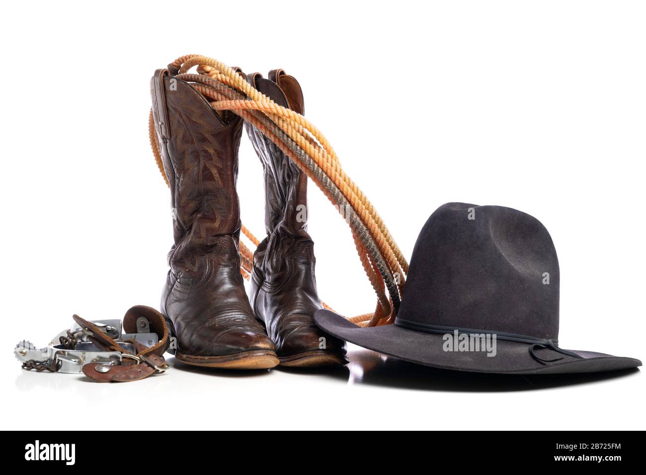 Bottes occidentales et une corde de tour ou de lariat et des espions et un chapeau de cowboy sur un fond blanc Banque D'Images