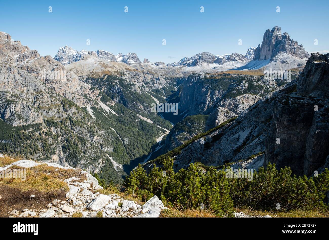 Surplombant une vallée boisée en forme de V profonde vers le spectaculaire Time Tre dans les Dolomites du nord de l'Italie Banque D'Images