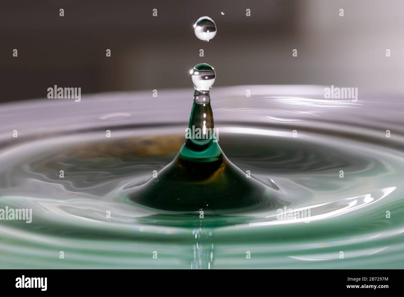 L'eau tombe par le dessus et éclate dans un bol d'eau Banque D'Images