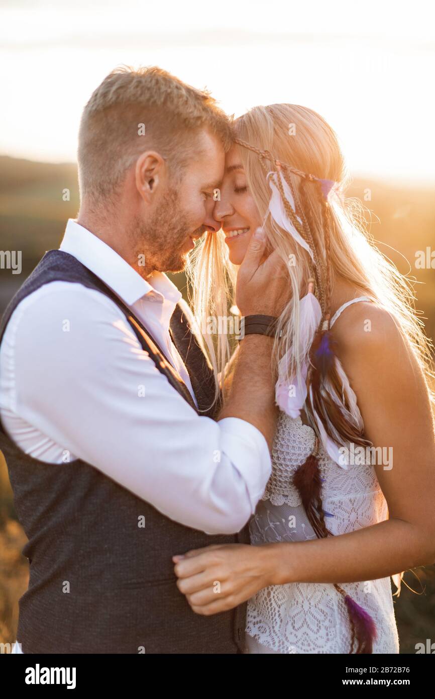 beau couple vetu de style boho s embrassant les uns les autres dans le champ ensoleille d ete. Beau homme dans un vetement decontracte et femme en robe blanche et Photo Stock Alamy