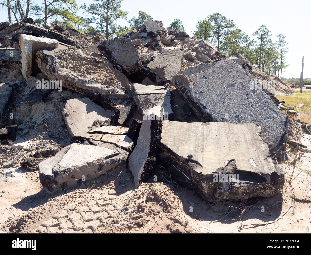 Énormes sections d'asphalte et de béton chaussée, chaussée, parking de débris au site de démolition de route, montagne de débris, chenilles de pneus d'équipement lourd Banque D'Images