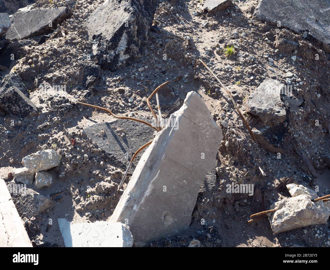 Débris de démolition de route pile, vue rapprochée du Rubble, morceaux de béton et de revêtement bitumineux, tuyaux en métal sortant de blocs de béton cassés Banque D'Images