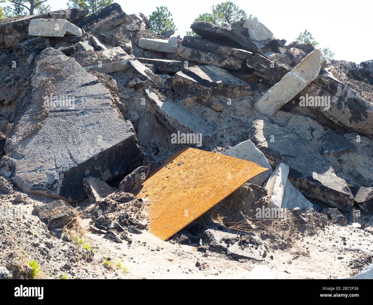 Masse pile de débris de route, ruble de démolition de route, site de démolition avec d'énormes sections de pavé de béton, asphalte, bordure et plaque métallique Banque D'Images