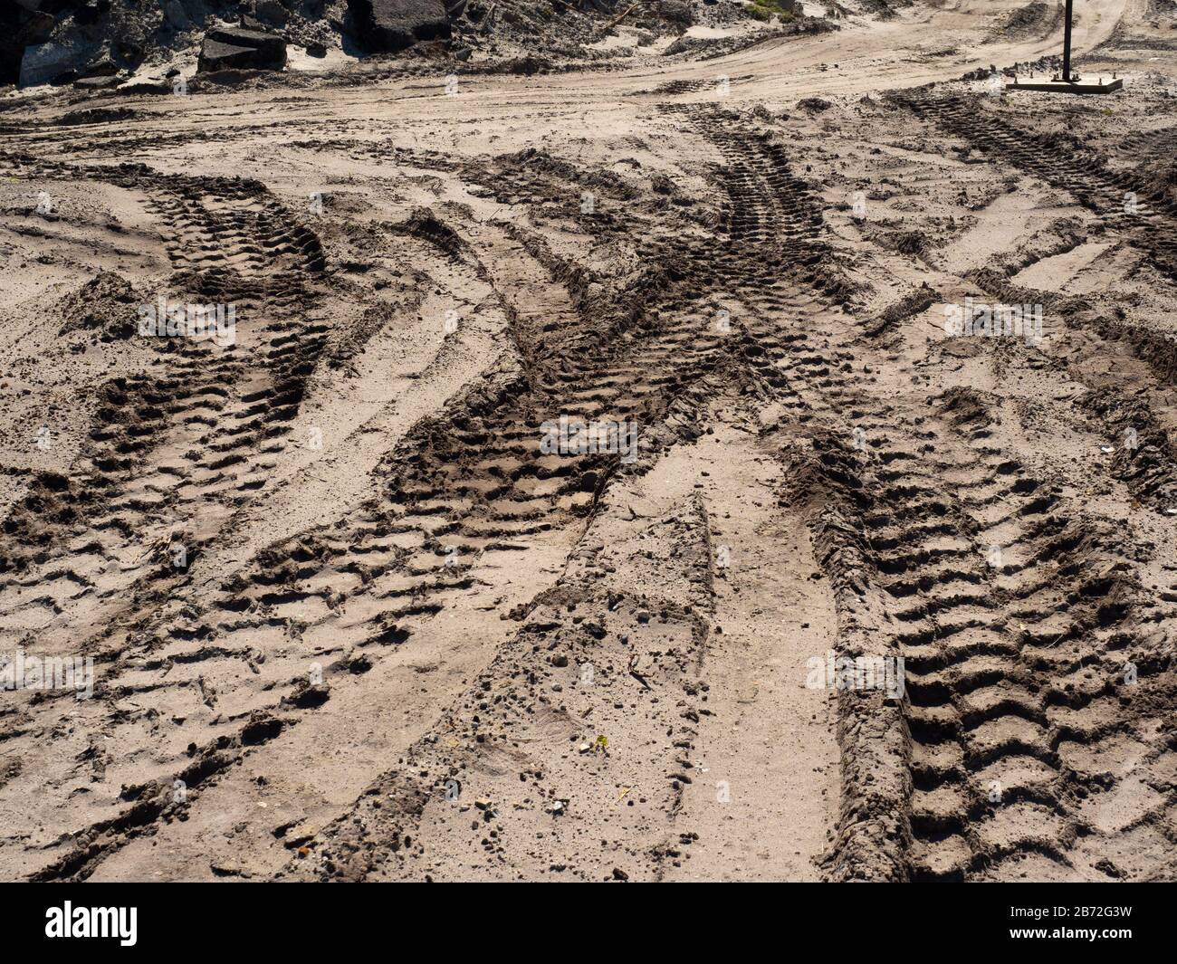 Équipement lourd chenilles de pneus dans le sable sur le site de démolition de route, grandes voies se chevauchant, tas de chaussées de route Rubble en arrière-plan, vue large Banque D'Images