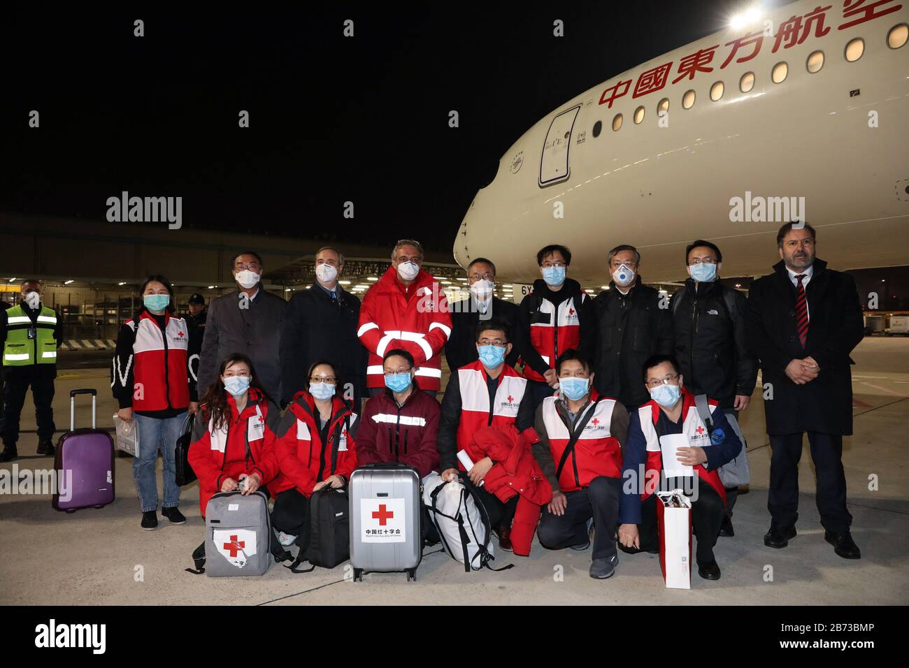 (200313) -- ROME, 13 mars 2020 (Xinhua) -- Président de la Croix-Rouge italienne Francesco Rocca (6 R, retour) pose pour des photos avec des membres de l'équipe d'aide chinoise à l'aéroport Fiumicino de Rome, Italie, 12 mars 2020. Un vol charter transportant une équipe d'aide chinoise composée de neuf membres, ainsi que des tonnes de fournitures médicales, est arrivé jeudi soir à l'aéroport Fiumicino de Rome, dans le cadre des efforts de la Chine pour aider l'Italie à contenir le nouvel épisode de coronavirus. (Tingting Xinhua/Cheng) Banque D'Images