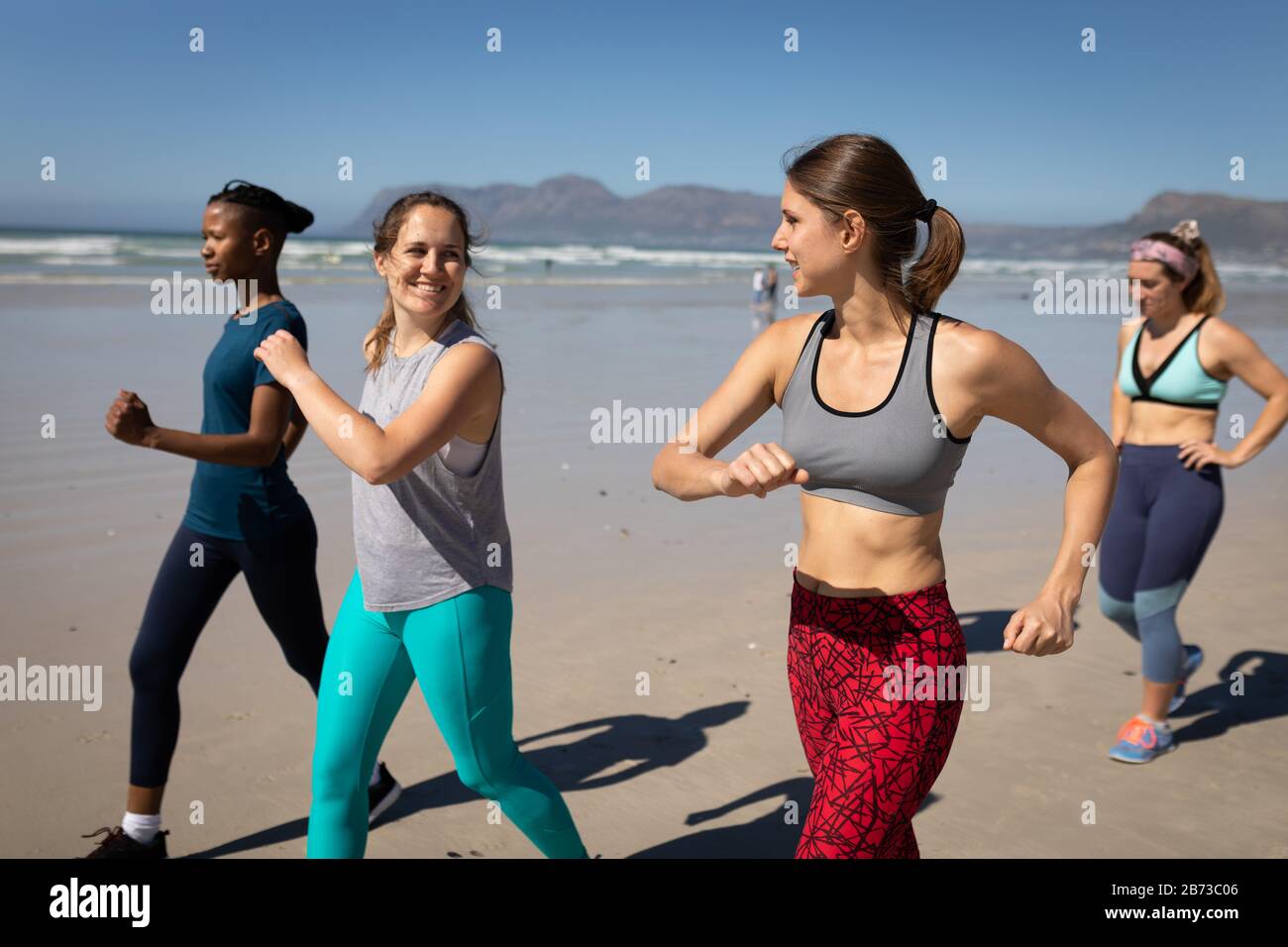 Vue latérale sur les femmes qui courir à la plage Banque D'Images