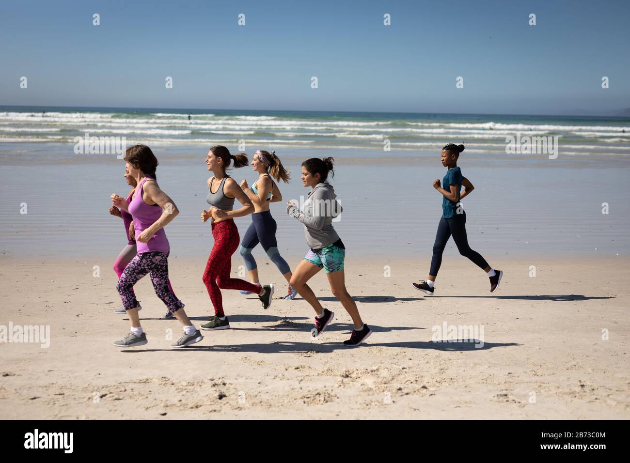 Vue latérale sur les femmes qui courir à la plage Banque D'Images