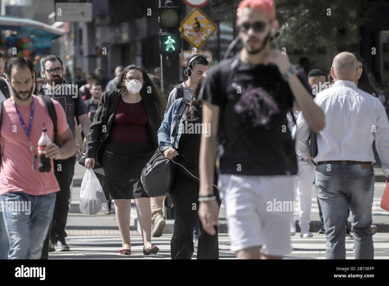 Sao Paulo, Brésil. 12 mars 2020. Une femme portant un masque de visage traverse l'avenue Paulista à Sao Paulo, Brésil, 12 mars 2020. Le Brésil a signalé 77 cas de COVID-19, dont 42 détectés dans l'état du sud-est peuplé de Sao Paulo. Crédit: Rahel Patrasso/Xinhua/Alay Live News Banque D'Images