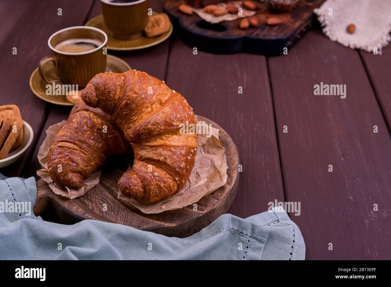 croissant et café. Pâtisseries italiennes fraîches et café aromatique sur une table en bois. Belle carte postale alimentaire. Espace de copie Banque D'Images