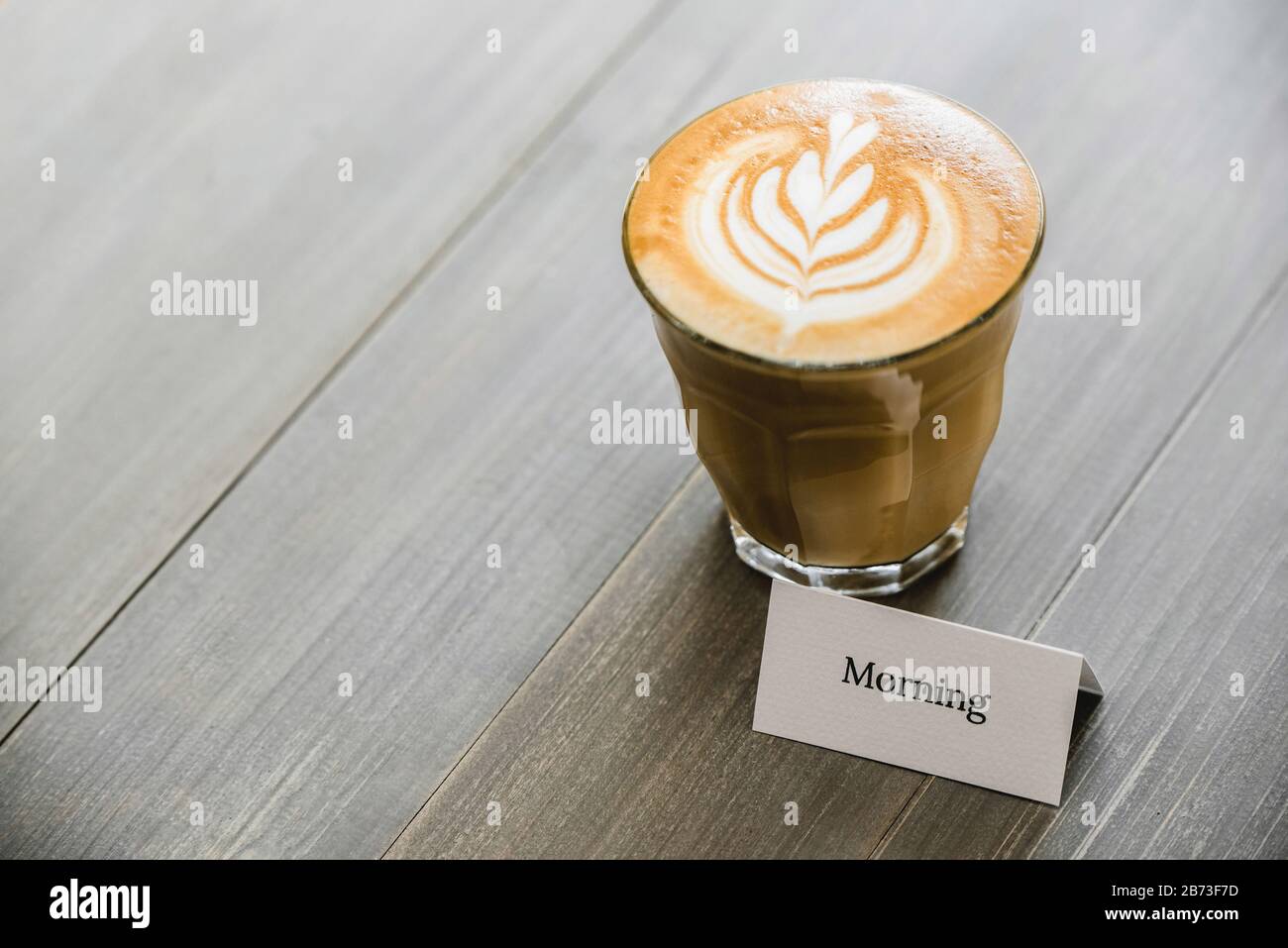 Café fraîchement préparé dans le verre à verres droits avec de beaux latte art sur table en bois prêt à boire Banque D'Images