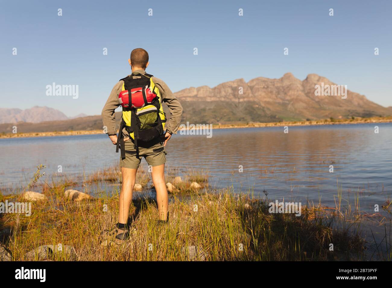 Vue arrière de l'homme avec sac à dos devant sur un lac Banque D'Images