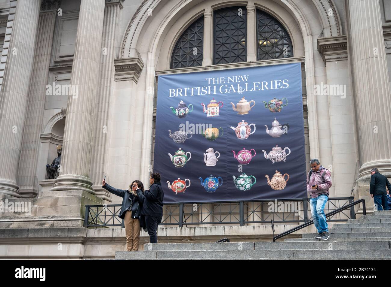 New York, États-Unis, 12 Mars 2020. Les visiteurs utilisent leur téléphone lorsqu'ils sortent du Metropolitan Museum of Art de la Cinquième Avenue de New York peu avant son clos Banque D'Images