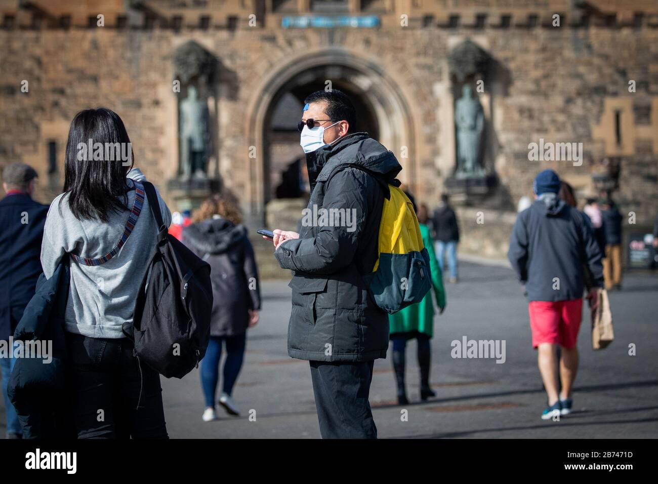 Un visiteur du château d'Édimbourg porte un masque protecteur alors que le meilleur scientifique du gouvernement a réchauffé jusqu'à 10 000 personnes au Royaume-Uni sont déjà infectées. Banque D'Images