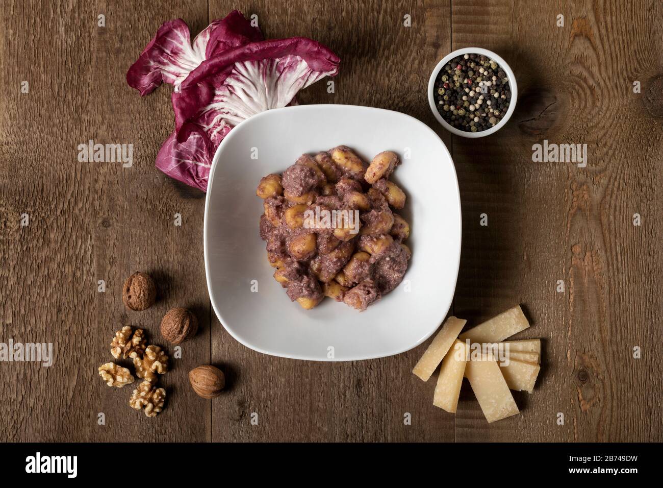 Boulettes de pommes de terre sans gluten avec sauce radicchio, noix, poivre et parmesan. Banque D'Images