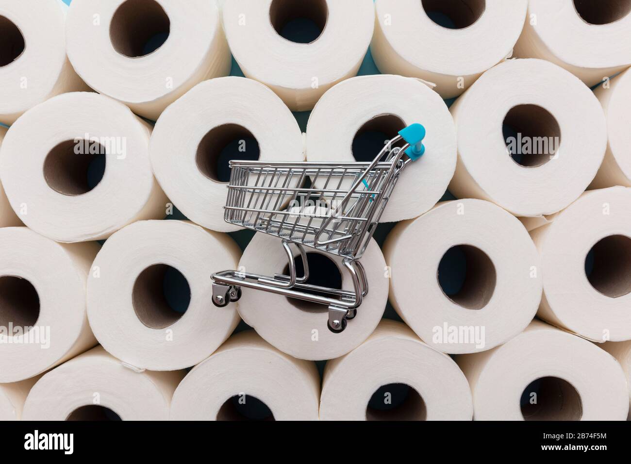 Supermarché shopping trollly sur un arrière-plan des rouleaux de papier de toilette Banque D'Images