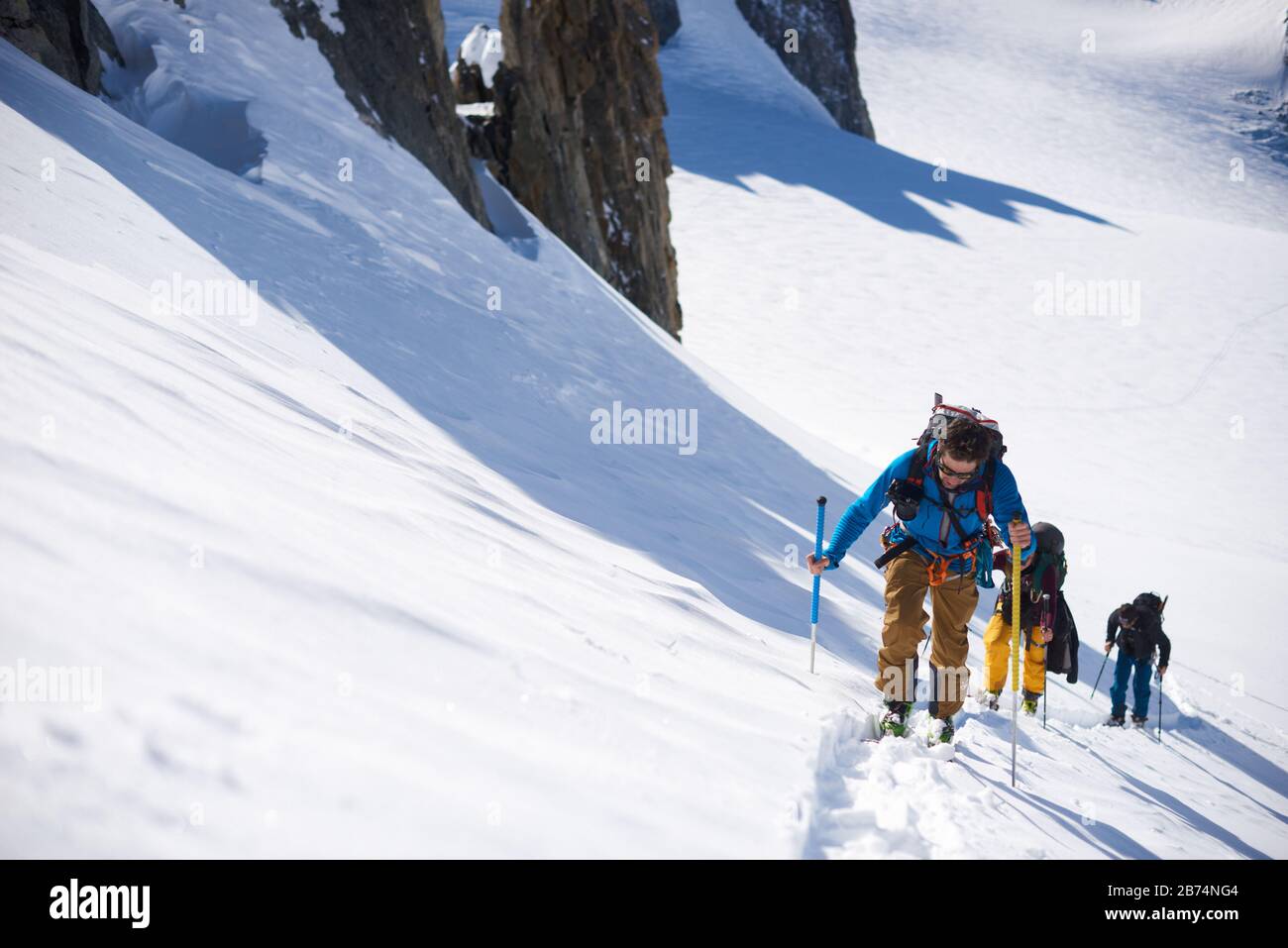 Groupe de 3 personnes en ski de randonnée en haut de la colline Banque D'Images