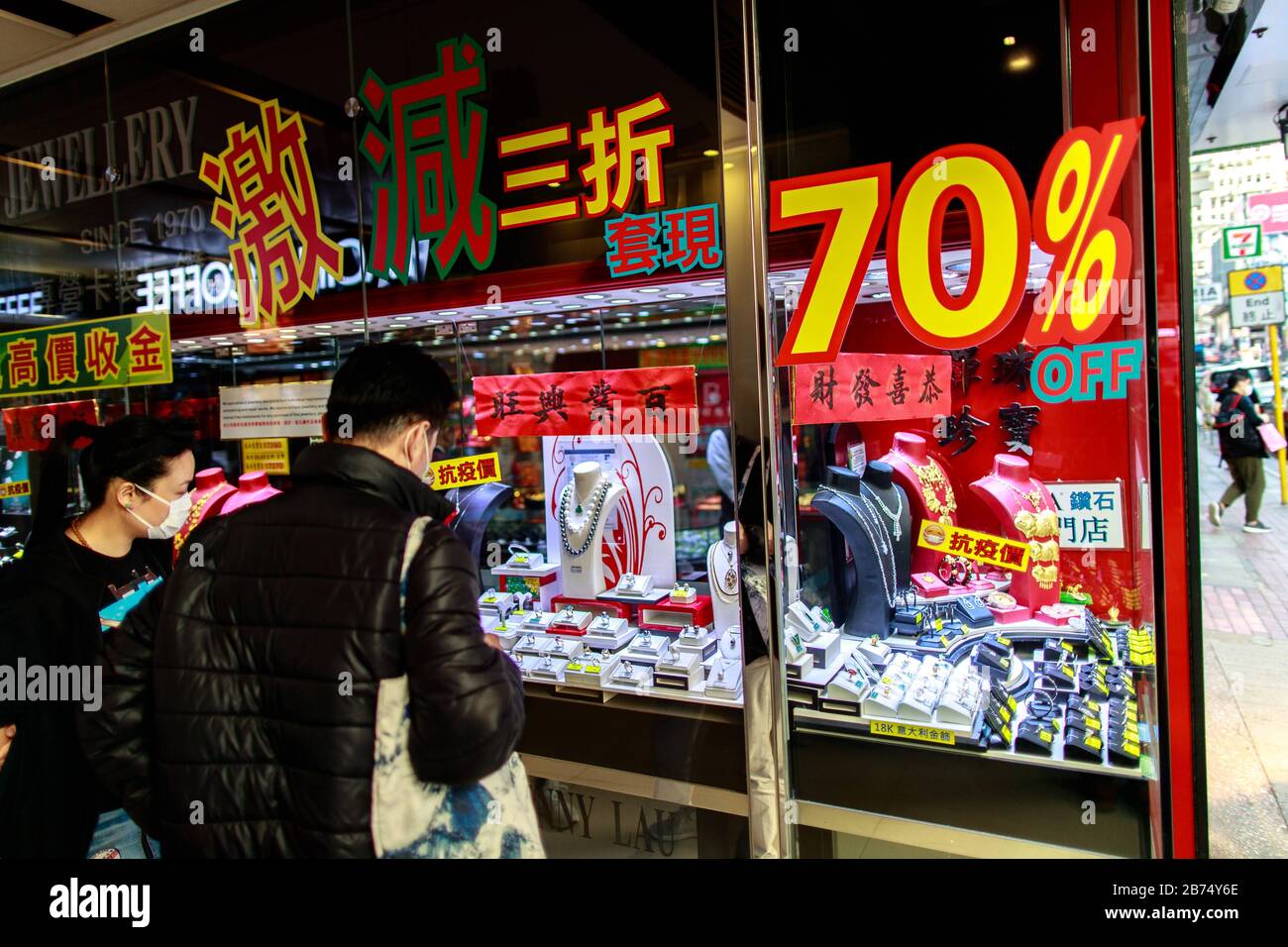 Les gens regarde les bijouteries dans une boutique qui affichent une réduction de 70% sur les diamants à Tsim Sha Tsui à Hong Kong. Banque D'Images