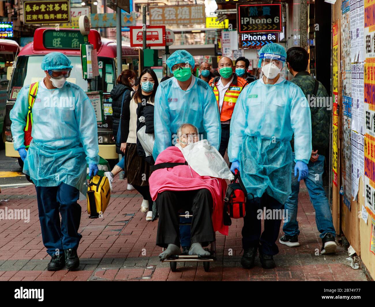 Ambulanceman en équipement de protection apporter un patient à l'hôpital de Hong Kong. Banque D'Images