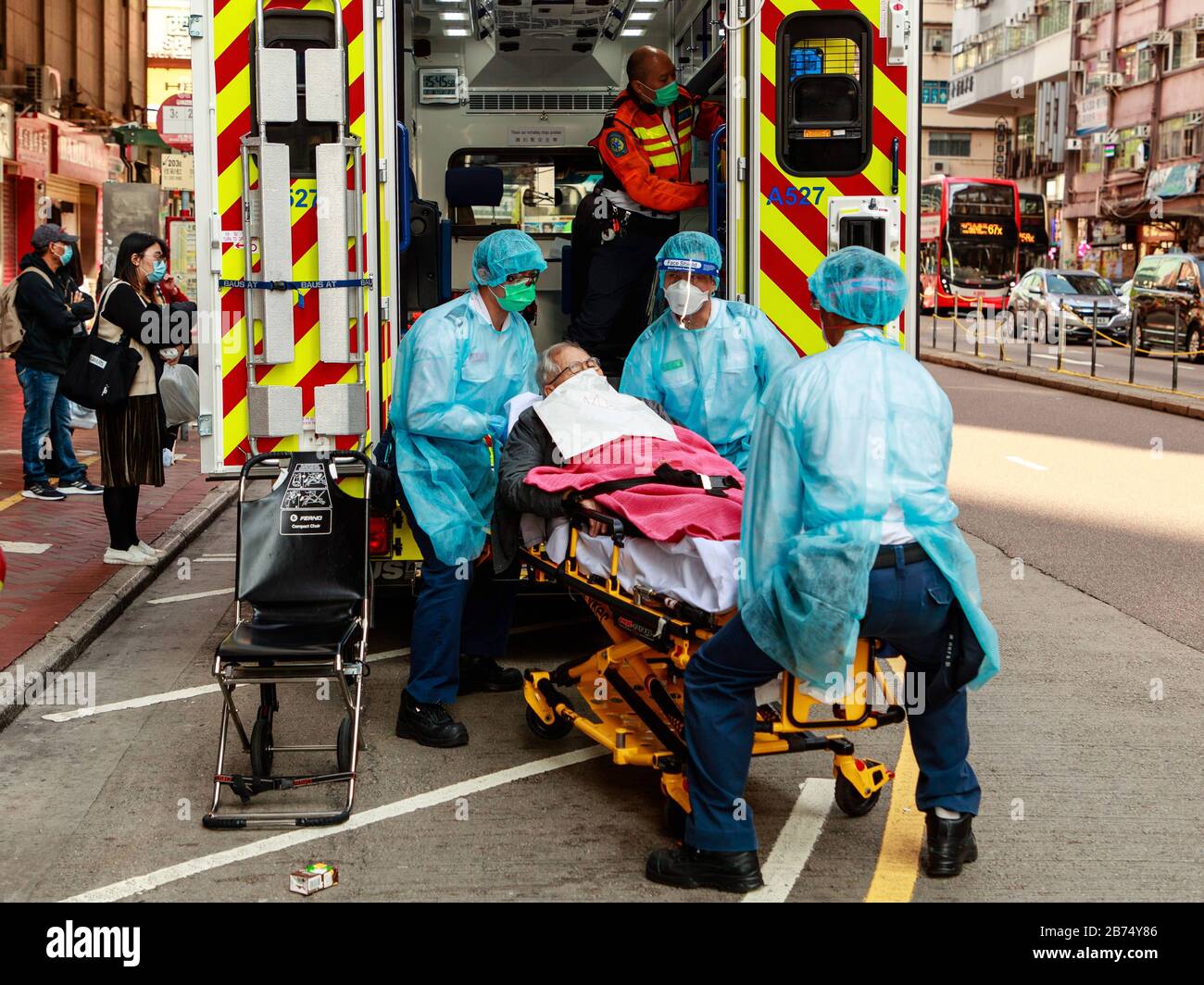Ambulanceman en équipement de protection apporter un patient à l'hôpital de Hong Kong. Banque D'Images