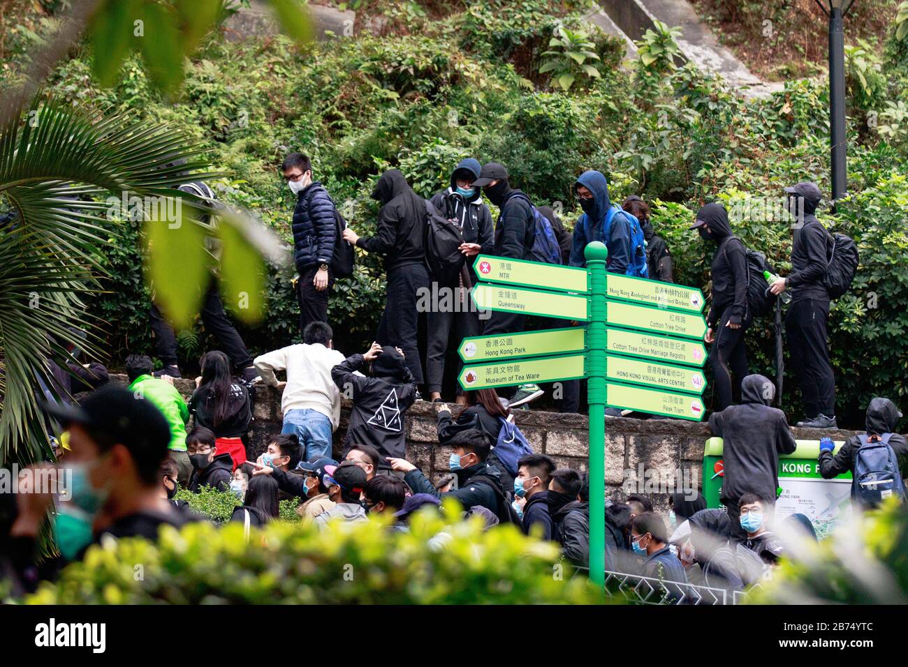 Les manifestants s'échappent lorsque la police a tiré du gaz lacrymogène au milieu d'un rassemblement contre le gouvernement à Charter Garden à Hong Kong. Banque D'Images