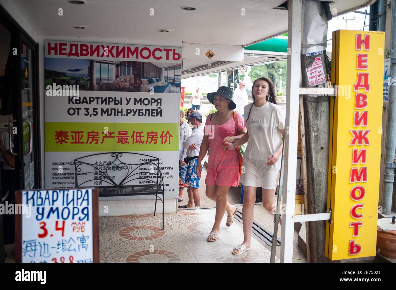 15.11.2019, Phuket, Thaïlande, Asie - touristes devant un bureau de vente avec des signes en cyrillique script à Karon Beach, une destination populaire pour les touristes russes. [traduction automatique] Banque D'Images