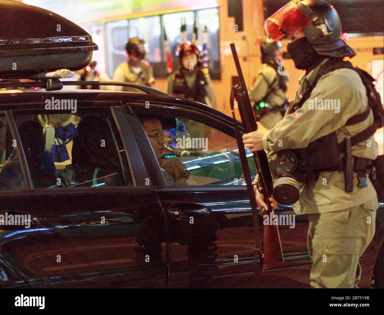 Un policier demande à un conducteur de faire un demi-tour alors que la route est bloquée. Les manifestants de Yuen long se tiennent debout avec la police à Hong Kong. Banque D'Images