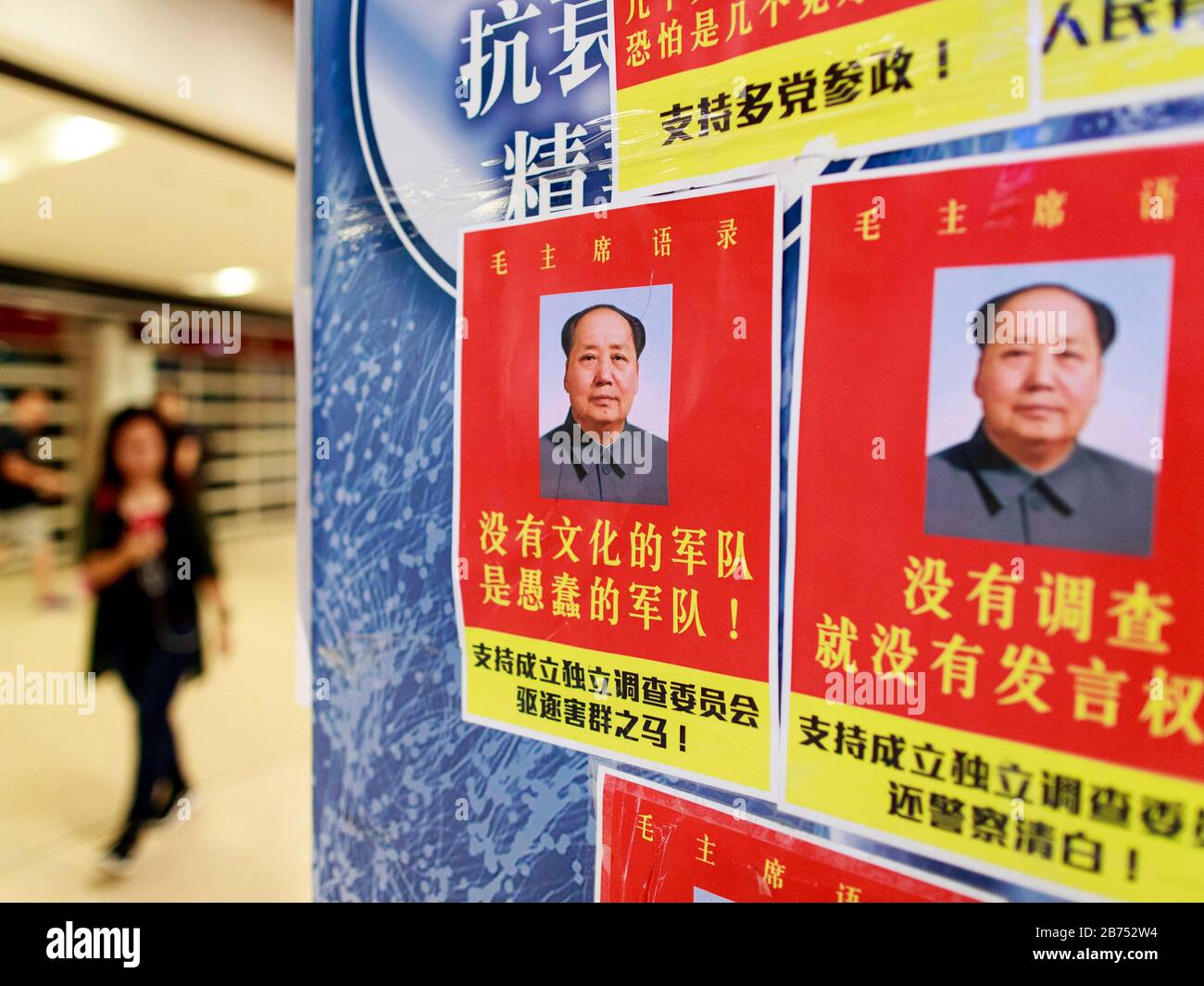 Posters read:'Une armée non instruite est une armée stupide-Mao Zedong'. La station de MTR de Shatin et la Plaza de la Nouvelle ville de Shatin ont été vandalisées après la manifestation. Les manifestants prétendent que la MTR a coopéré avec la police. Banque D'Images