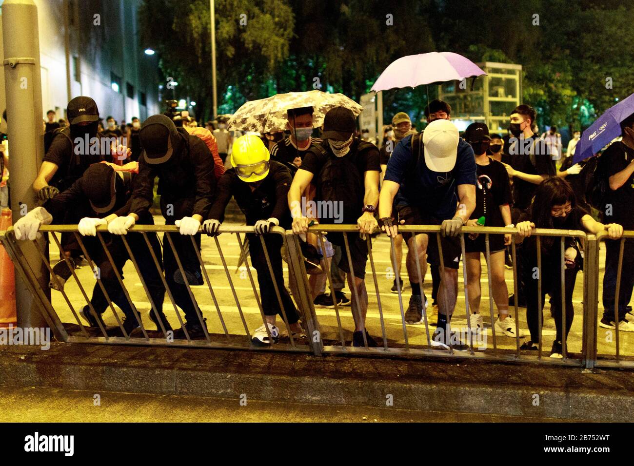 Les manifestants retiens une clôture pour installer une barrière à l'extérieur du lieu où le leader de Hong Kong Carrie Lam organise une « réunion de l'hôtel de ville » avec 150 Hong Kongers au stade Queen Elizerbeth à Hong Kong. Ces 150 Kongers de Hong ont été tirés de 20 000 personnes. Banque D'Images
