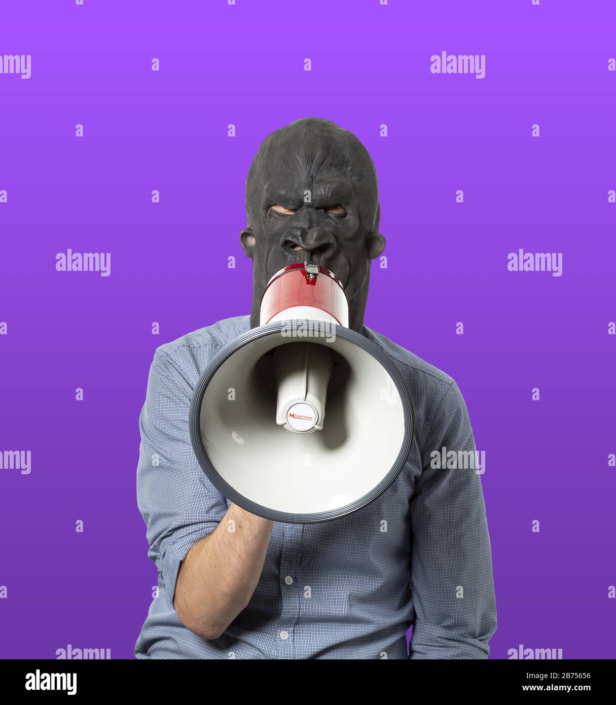 Homme dans un masque noir en colère parlant sur un mégaphone Banque D'Images