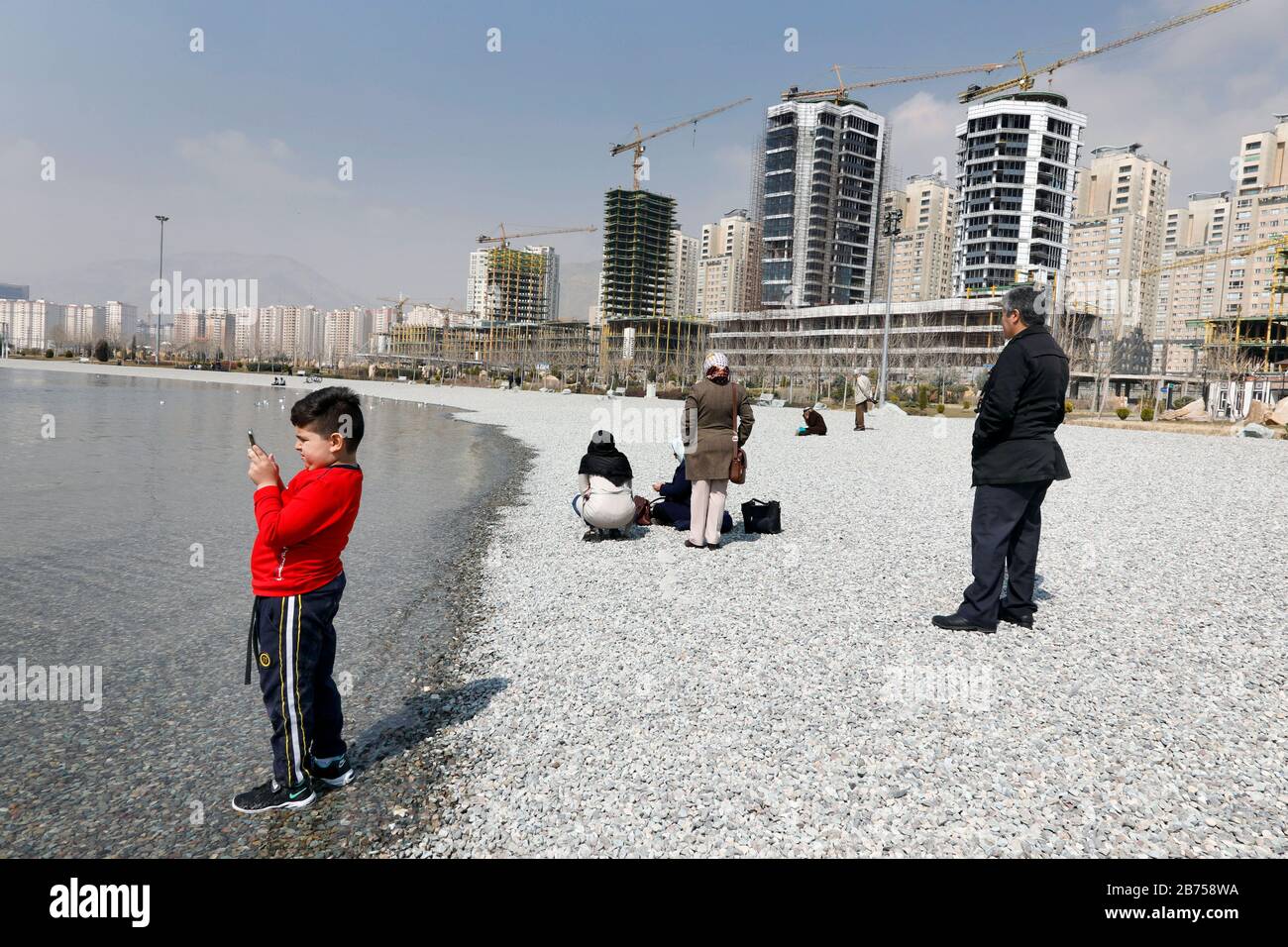 Une famille sur la plage du lac de Chitgar à Téhéran, en Iran, le 10.03.2019. Le lac Chitgar est un lac artificiel, au nord-ouest de Téhéran. Le complexe, également connu sous le nom de lac des Martyrs du golfe Persique, a une superficie totale d'environ 250 hectares. Une fois que les États-Unis se sont retirés de l'accord nucléaire international, le pays impose de nouveau des sanctions contre l'Iran. [traduction automatique] Banque D'Images