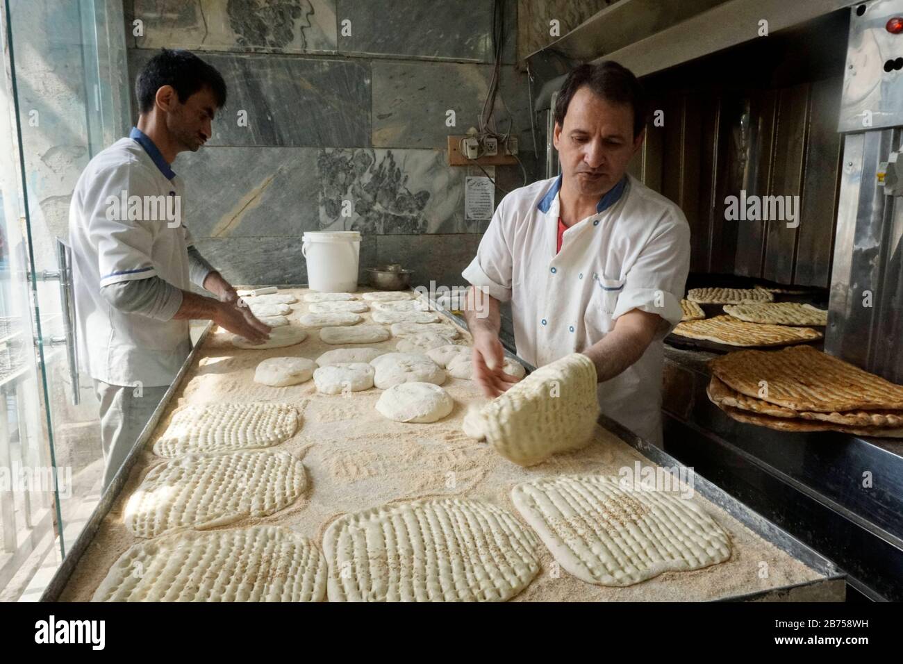 Les boulangers cuisent du pain frais dans une boulangerie de Téhéran, en Iran, le 9 mars 2019. Une fois que les États-Unis se sont retirés de l'accord nucléaire international, le pays impose de nouveau des sanctions contre l'Iran. [traduction automatique] Banque D'Images