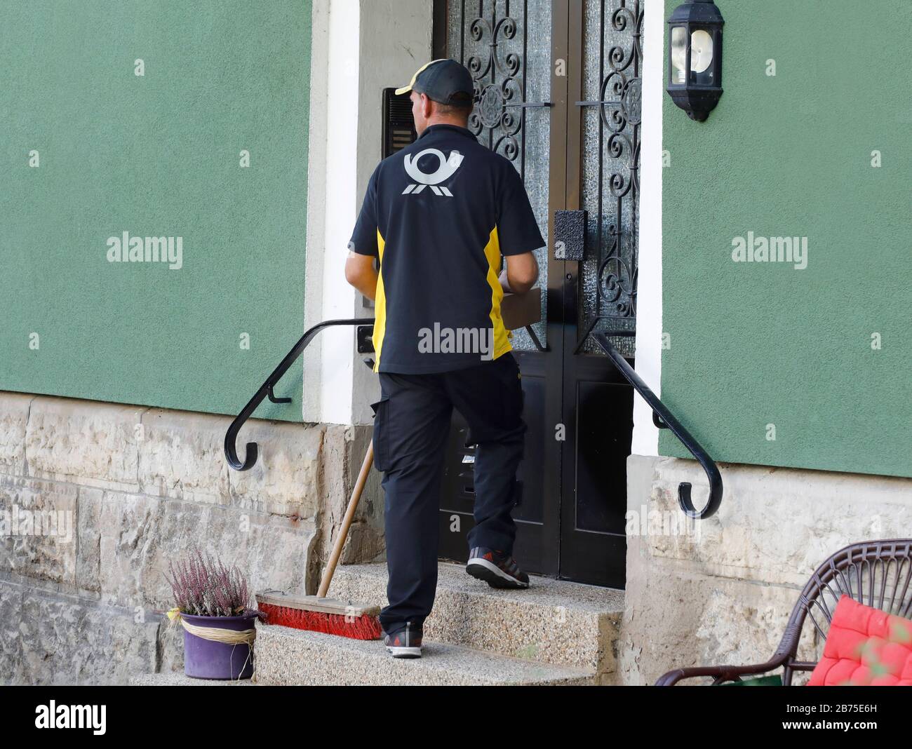 Un livreur DHL avec le paquet en main attend sur les escaliers d'une maison à une porte d'entrée pour être laissé dans, le 06.10.2018. [traduction automatique] Banque D'Images