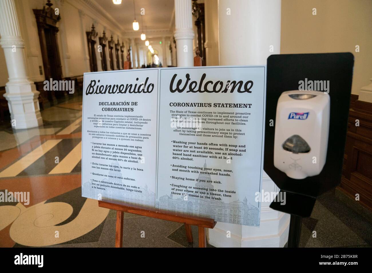 Texas, États-Unis. 13 mars 2020. Des signes bilingues avertissant le coronavirus accueillent les visiteurs au Capitole du Texas à Austin, où Gov. Greg Abbott a tenu une conférence de presse plus tôt déclarant un « état de catastrophe » à l'échelle de l'État, tandis que le Texas s'attelle à une attaque de cas de coronavirus. Un distributeur de désinfectant pour les mains se trouve à côté des panneaux Credit: Bob Daemmrich/Alay Live News Banque D'Images