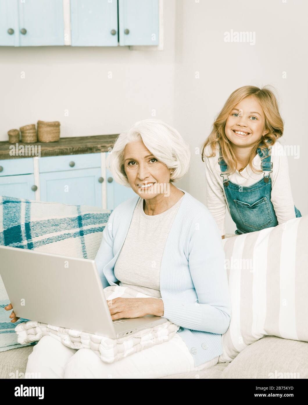 Adorable petite-fille enseigner sa grand-mère Comment jouer sur ordinateur bonne Granny à l'aide de l'ordinateur portable gai Dames joyeuses Smiling pour appareil photo, tonifiée i Banque D'Images