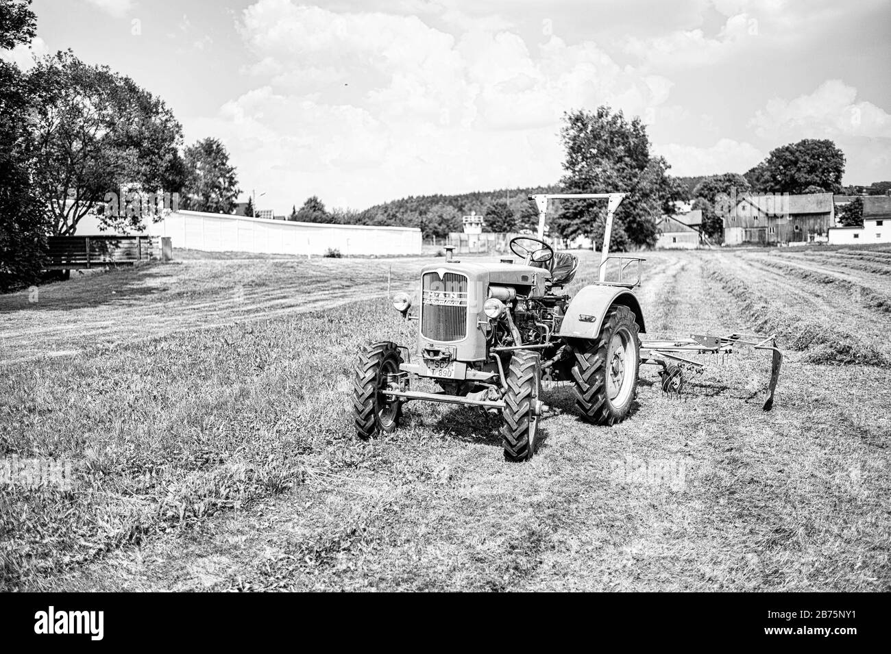Un tracteur se trouve sur un terrain de Mödlareuth, en Haute-Franconie, à la frontière entre la Bavière et la Thuringe. Jusqu'en 1989, la frontière germano-allemande et le mur des frontières couraient directement au milieu du village, c'est pourquoi les troupes américaines locales l'appelaient "petit Berlin". [traduction automatique] Banque D'Images