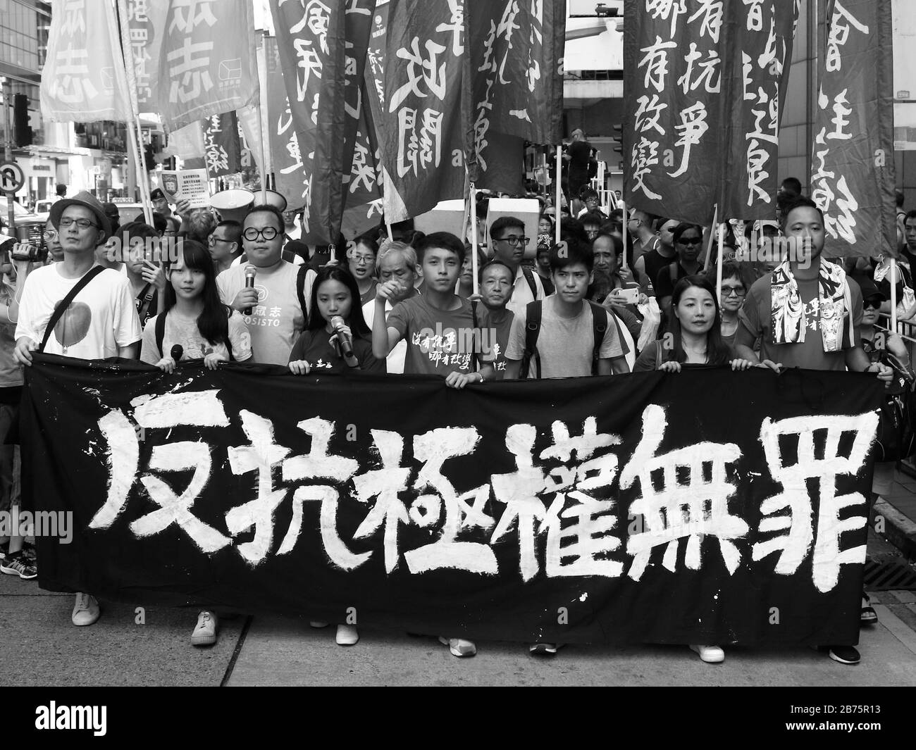 Les manifestants pro-démocratie protestent contre l'emprisonnement des 16 militants pro-démocratie récents, dont Nathan Law, Joshua Wong et Alex Chow à Hong Kong. Les dirigeants de procession, qui comprenaient des législateurs et des militants pandémocratiques, ont tenu une longue bannière qui a lu "aucun crime pour lutter contre un gouvernement totalitaire". Law, Wong, et Chow ont été accusés d'avoir pris le pouvoir de l'enceinte du gouvernement de Hong Kong ­headquarters qui a déclenché le mouvement central d'occupation de 79 jours. Le gouvernement est accusé d'utiliser des moyens juridiques pour réprimer la démocratie à Hong Kong. Banque D'Images