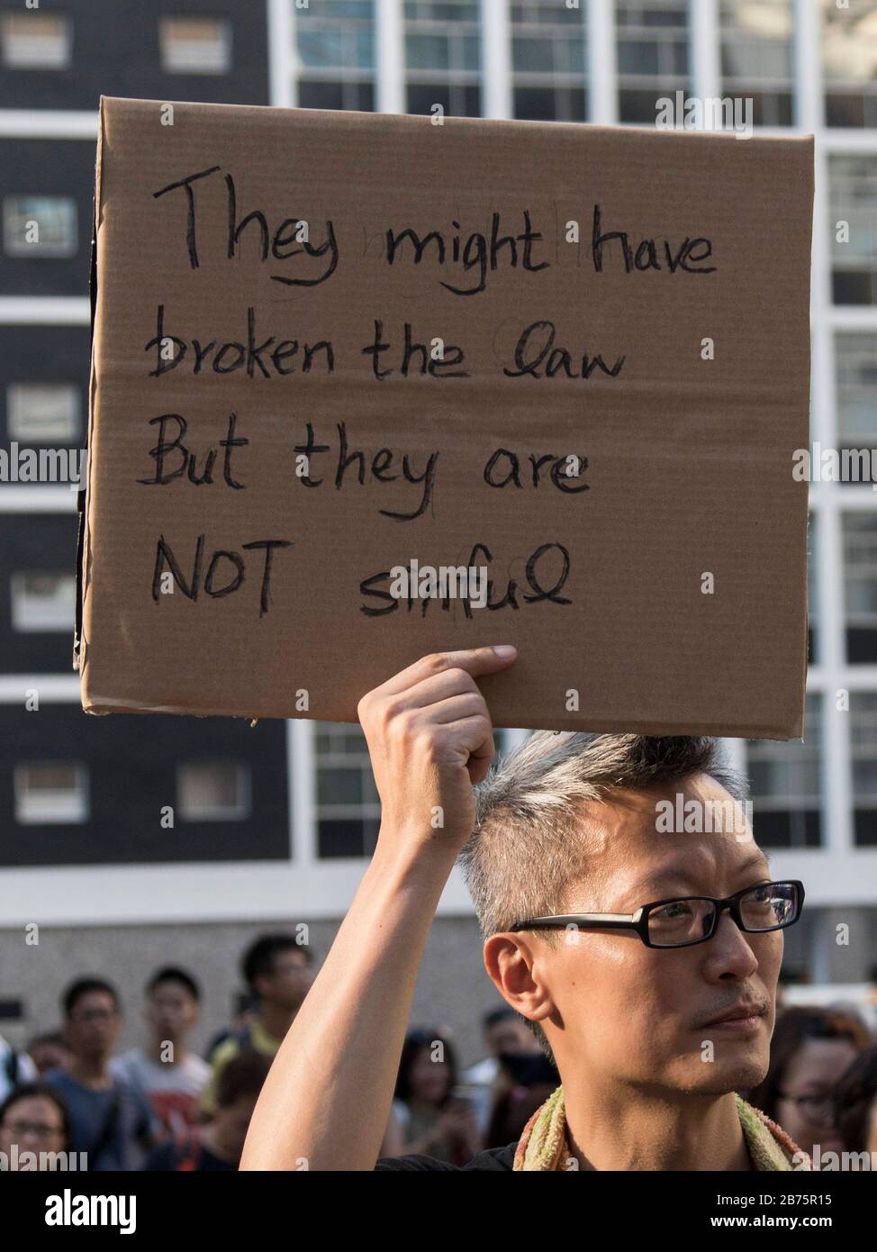 Un manifestant tient un pancartes pour protester contre l'emprisonnement des 16 militants pro-démocratie récents, dont Nathan Law, Joshua Wong et Alex Chow à Hong Kong. Law, Wong, et Chow ont été emprisonnés parce qu'ils ont pris la tempête du composé ­headquarters du gouvernement de Hong Kong qui a déclenché le mouvement Central D'Occupation de 79 jours. Le gouvernement est accusé d'utiliser des moyens juridiques pour réprimer la démocratie à Hong Kong. Banque D'Images