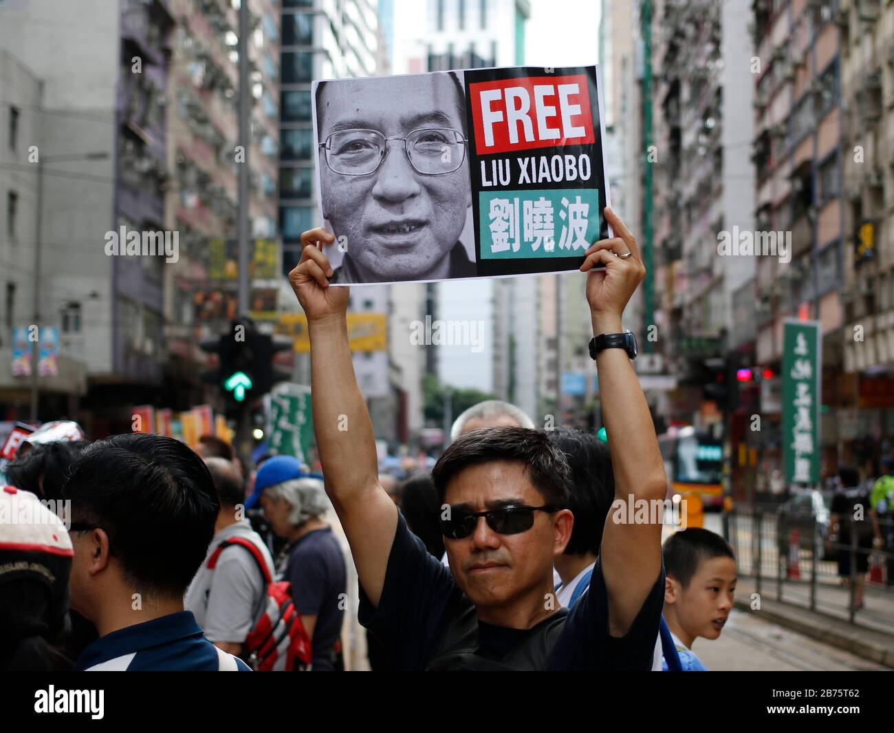 Un homme a une photo de Liu Xiaobo lors du rassemblement annuel pro-démocratie à Hong Kong, Chine, le 1er juillet 2017. Le président chinois Xi Jinping a inauguré un nouveau directeur général de Hong Kong et a marqué le vingtième anniversaire de la remise de la ville de la domination britannique à la règle chinoise le 1er juillet. Banque D'Images