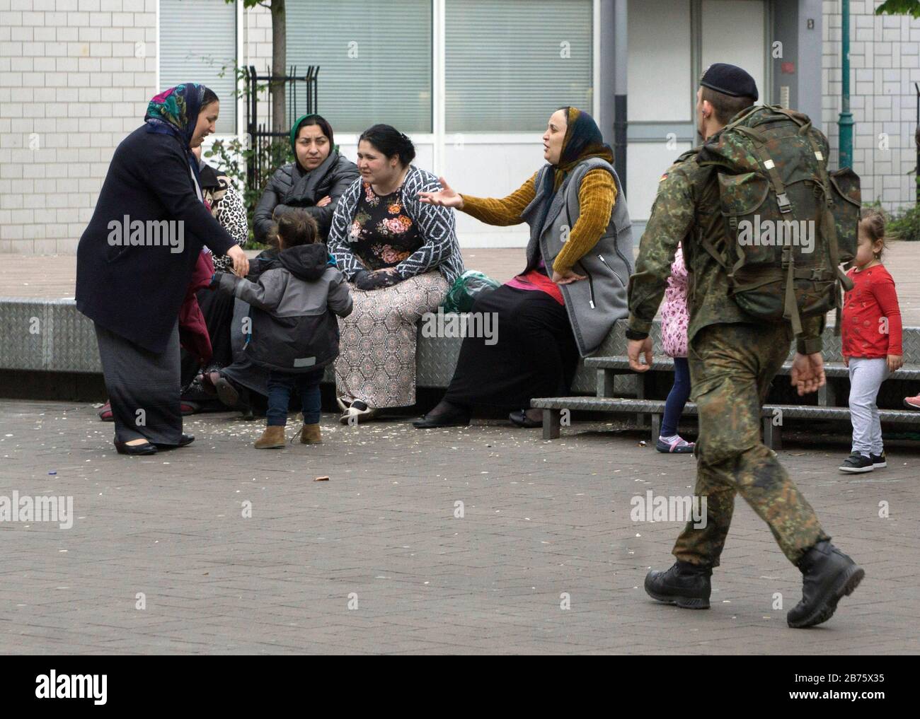 Un soldat de la Bundeswehr passe devant les femmes roms dans une rue commerçante de Duisburg-Marxloh le 21 avril 2017. Avec un taux de chômage de 13%, janvier 2017, et une part des étrangers de près de 20%, la ville de Duisburg est confrontée à de grands problèmes sociaux. [traduction automatique] Banque D'Images