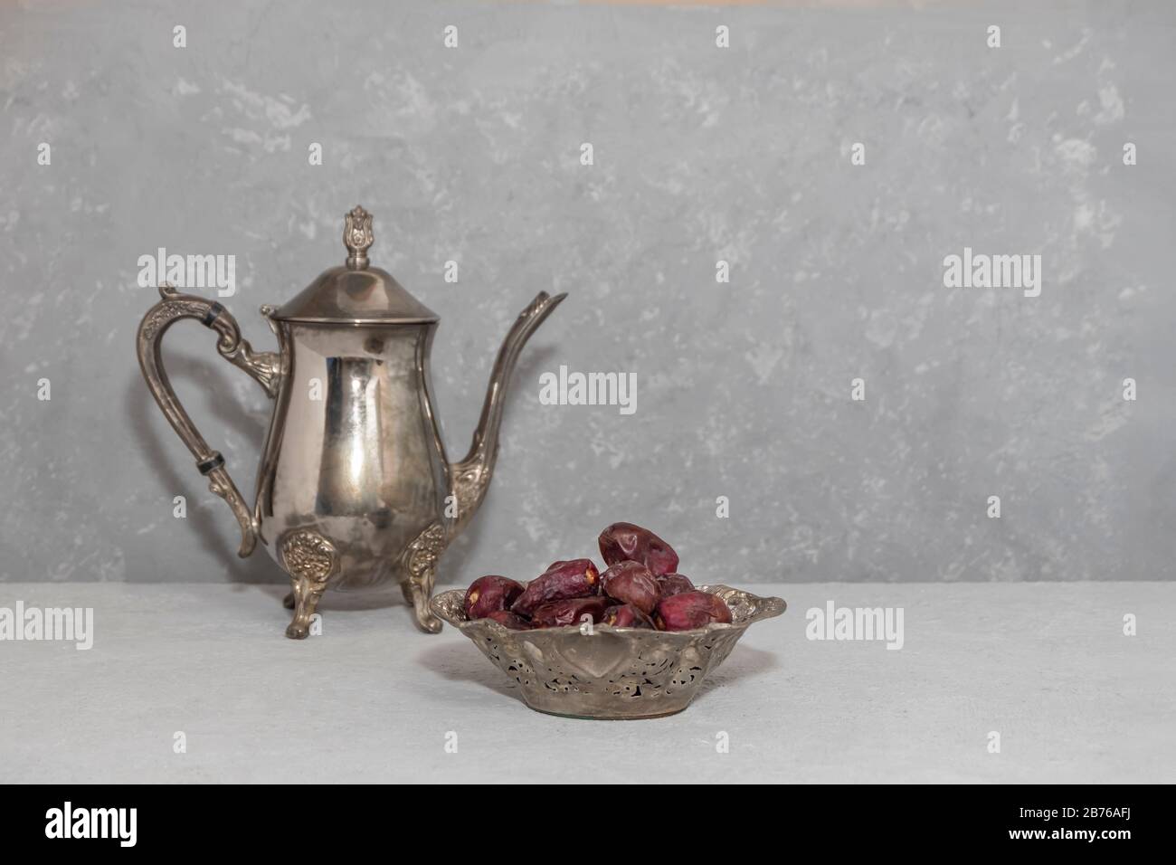 Composition du Ramadan avec dates sèches et théière vintage sur fond gris neutre, espace de copie Banque D'Images